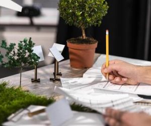 side-view-man-working-eco-friendly-wind-power-project-with-paper-plans